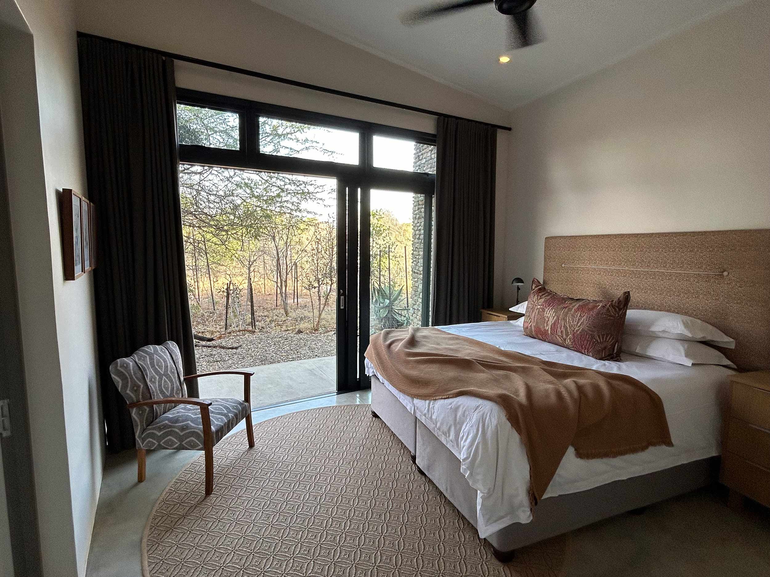 Bedroom with bed, armchair, and sliding glass doors